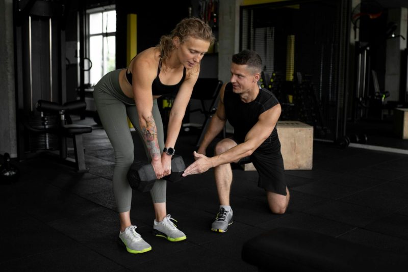 full-shot-man-helping-woman-gym